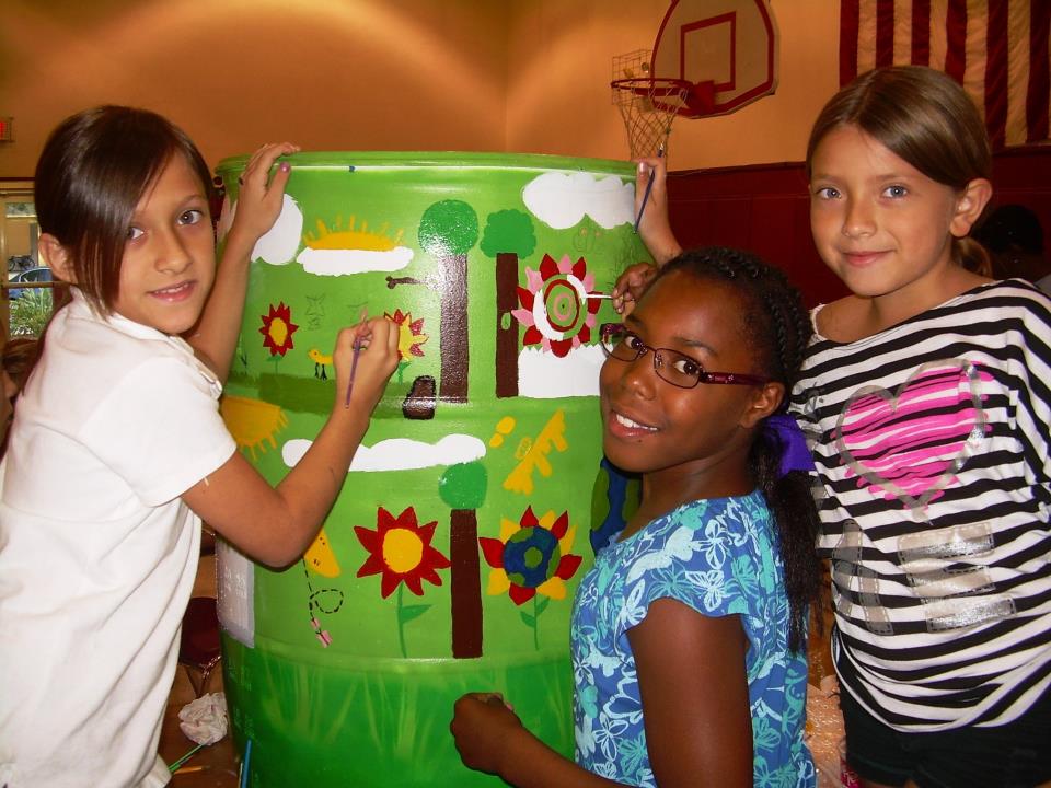 Kids painting a rain barrel